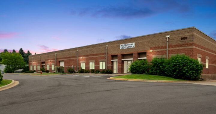 The exterior of the Quantum Controls headquarters and manufacturing facility at twilight, featured alongside the announcement that the company is continuing forward with new ownership and the same commitment to quality.